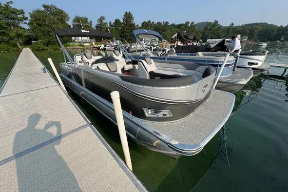 Slide: The Image of 2025 Tahoe Pontoon 25 LSZ Versatile Rear Bench docked on a serene lake. - 1