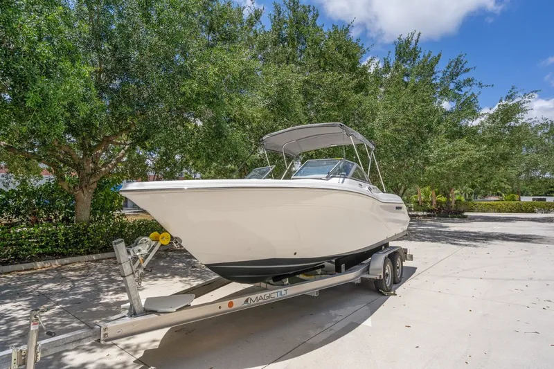 Slide: The Image of 2025 Sea Fox 228 Traveler boat on trailer, parked outdoors under trees. - 1