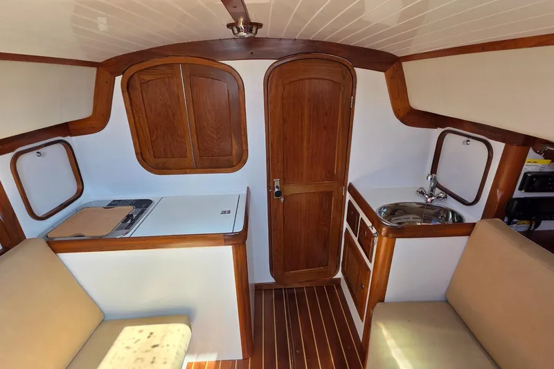 Slide: The Image of Interior of 2020 Alerion Express 33 sailboat with wood finish and compact kitchen area. - 19