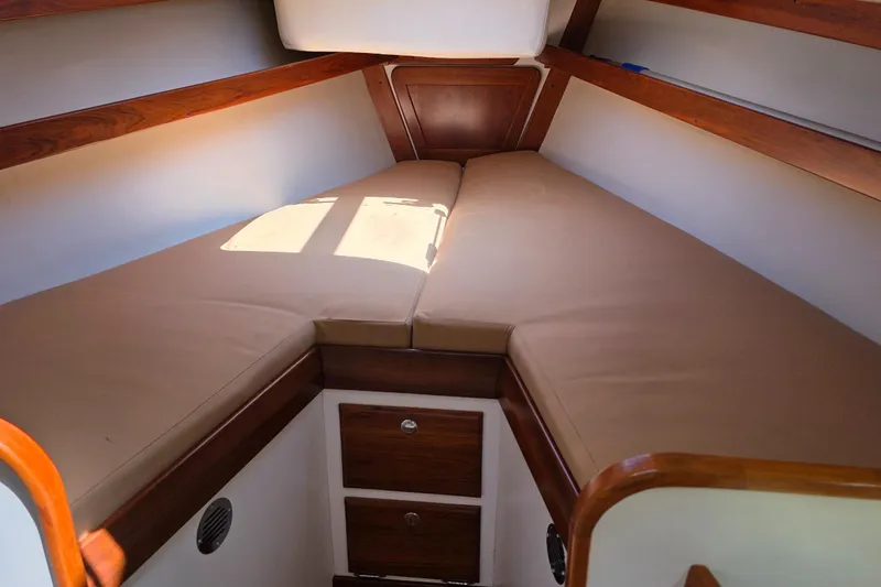 Slide: The Image of 2020 Alerion Express 33 cabin interior with cozy V-berth and wooden accents. - 26