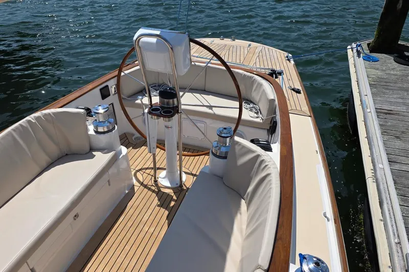 Slide: The Image of 2020 Alerion Express 33 sailboat cockpit with wooden deck and cushioned seating. - 3