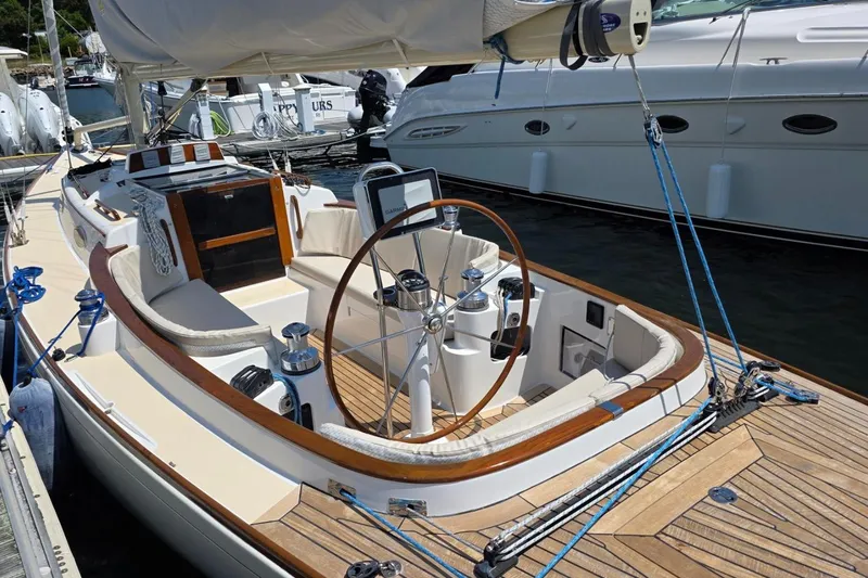 Slide: The Image of Alerion Express 33 sailboat, 2020 model, docked with wooden deck and steering wheel. - 5
