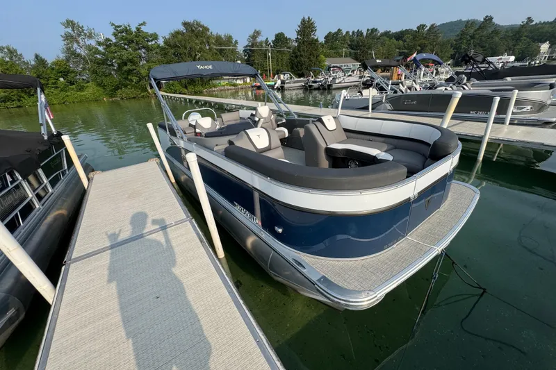 Slide: The Image of 2025 Tahoe Pontoon 23 LSZ Quad Bench docked on a serene lake. - 3