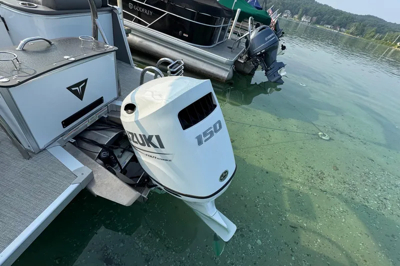 Slide: The Image of 2025 Tahoe Pontoon 23 LSZ Quad Bench with Suzuki 150 outboard motor on clear lake. - 5