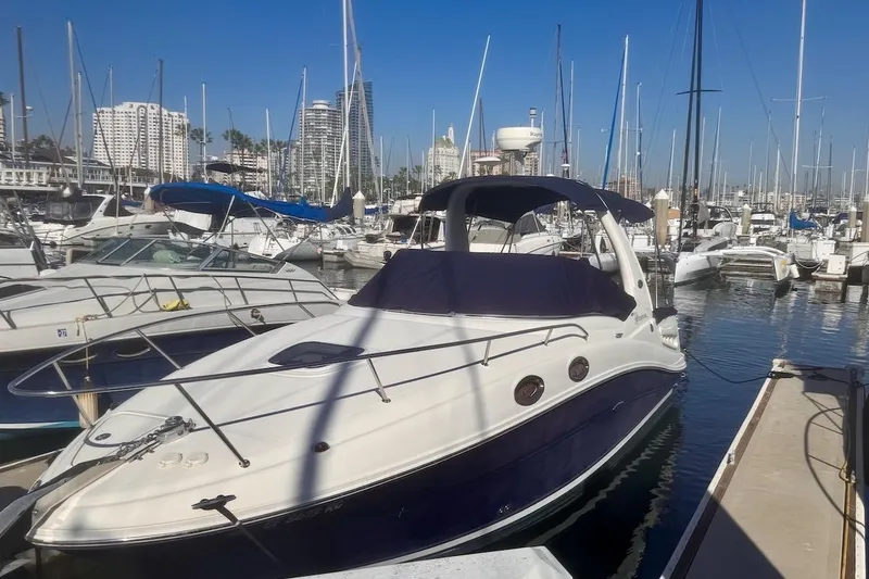 The Image of 2005 Sea Ray Sundancer 260 docked in a marina with other boats. - 0