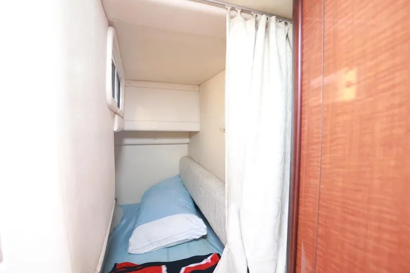 Slide: The Image of 2005 Sea Ray Sundancer 260 cabin interior with bed and curtain. - 11