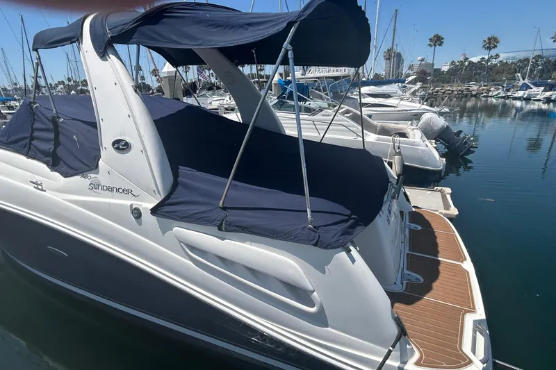 Slide: The Image of 2005 Sea Ray Sundancer 260 interior with helm, seating, and marina view. - 5