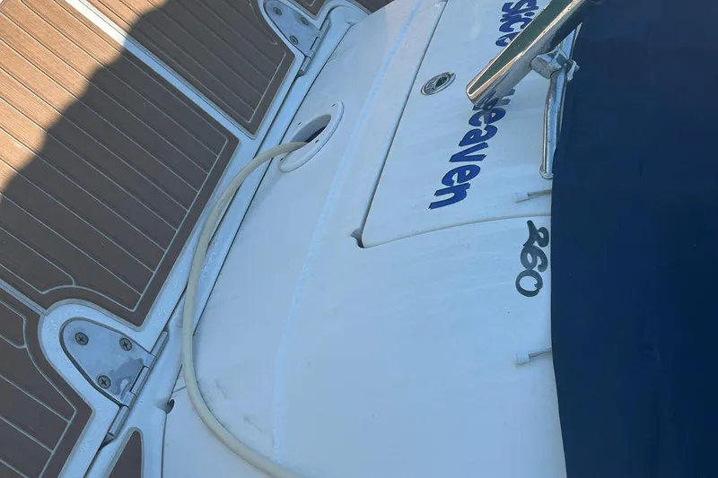 Slide: The Image of Interior of 2005 Sea Ray Sundancer 260, featuring cozy seating and compact kitchen area. - 7