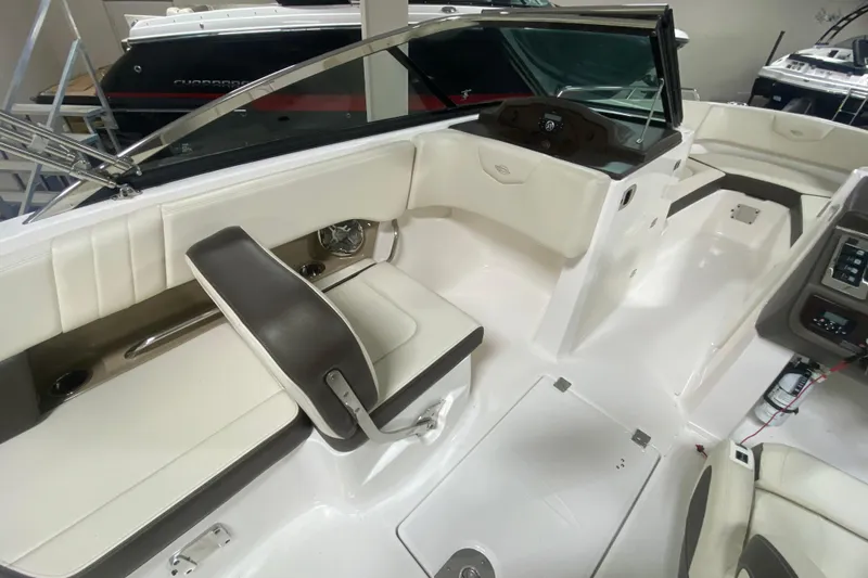 Slide: The Image of 2020 Chaparral 237 SSX boat interior with white seating and modern dashboard. - 6
