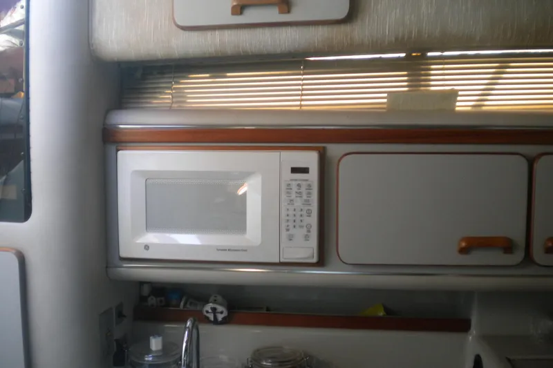 Slide: The Image of Interior of 1990 Sea Ray 310 Sundancer with microwave and cabinets. - 12
