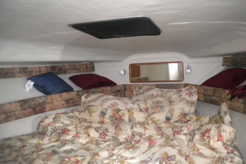 Slide: The Image of Cozy cabin interior of 1990 Sea Ray 310 Sundancer with floral bedding and pillows. - 19