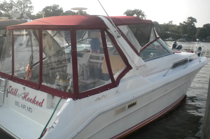 Slide: The Image of 1990 Sea Ray 310 Sundancer boat docked with maroon canopy, named "Still Hooked," Bel Air, MD. - 2