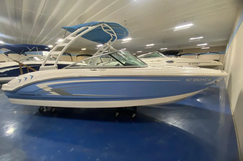 The Image of 2023 Chaparral 21 SSi boat in showroom, featuring sleek blue and white design. - 1