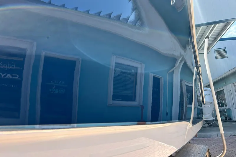 Slide: The Image of 2019 Sea Hunt Gamefish 27 boat with reflective blue hull in a marina setting. - 21