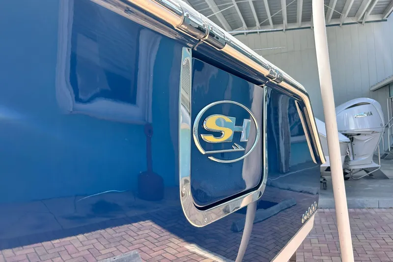 Slide: The Image of 2019 Sea Hunt Gamefish 27 boat with SH logo, blue exterior, and Yamaha engine in background. - 22