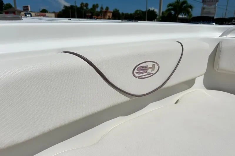 Slide: The Image of 2019 Sea Hunt Gamefish 27 Forward Seating interior detail with logo, showcasing white upholstery. - 27