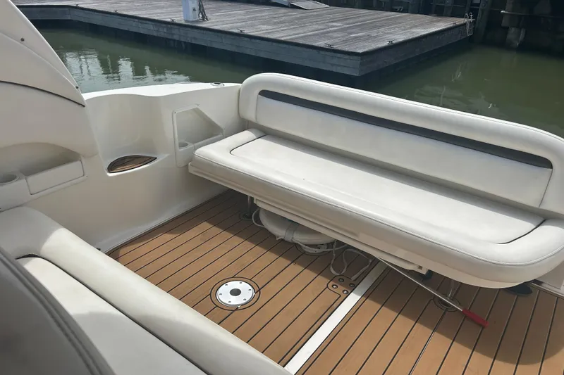 Slide: The Image of 2005 Sea Ray 360 Sundancer boat interior with white seating and wooden deck. - 13