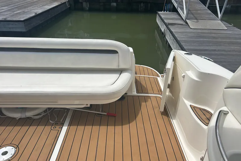 Slide: The Image of 2005 Sea Ray 360 Sundancer boat deck with white seating and wooden flooring at a dock. - 16