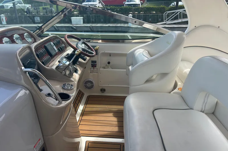 Slide: The Image of 2005 Sea Ray 360 Sundancer cockpit with leather seats and wooden flooring. - 19
