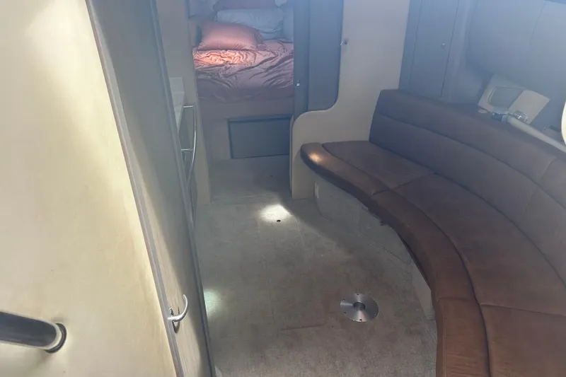 Slide: The Image of Interior of 2005 Sea Ray 360 Sundancer with brown leather seating and cozy sleeping area. - 24
