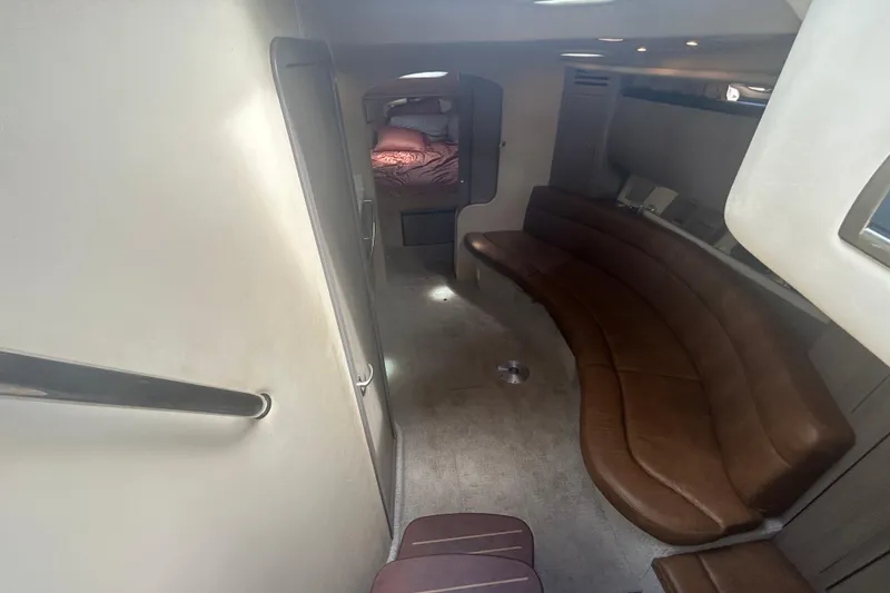Slide: The Image of 2005 Sea Ray 360 Sundancer interior with brown leather seating and cozy sleeping area. - 25