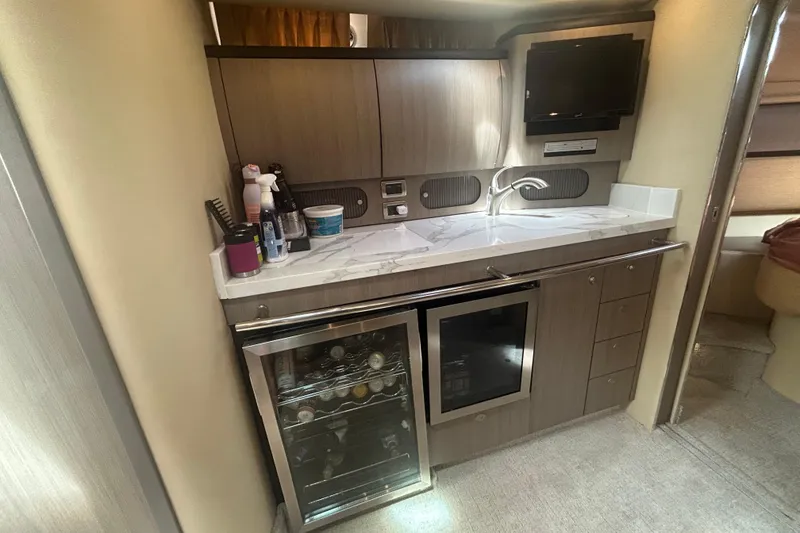 Slide: The Image of 2005 Sea Ray 360 Sundancer galley with modern cabinetry, mini-fridge, and countertop appliances. - 31