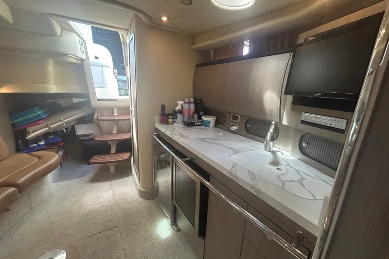 Slide: The Image of 2005 Sea Ray 360 Sundancer interior with kitchenette, seating, and storage. - 35