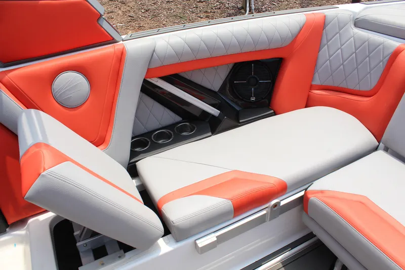Slide: The Image of 2020 Tigé 23ZX boat interior with orange and gray seating, cup holders, and speaker. - 11