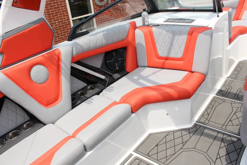 Slide: The Image of 2020 Tigé 23ZX boat interior with orange and gray seating, cup holders, and speaker. - 12