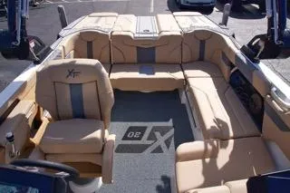 Slide: The Image of 2025 MasterCraft XT20 boat interior with beige seating and modern design. - 10