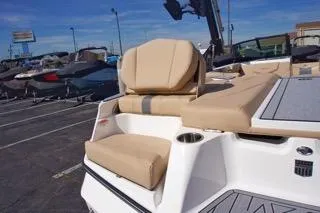 Slide: The Image of 2025 MasterCraft XT20 boat with beige seating, parked outdoors under a clear blue sky. - 14