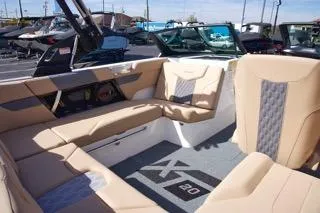 Slide: The Image of 2025 MasterCraft XT20 boat interior with beige seating and modern design. - 8
