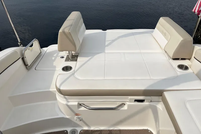 Slide: The Image of 2013 Sea Ray 280 Sundeck boat interior with white seating and cup holders. - 10