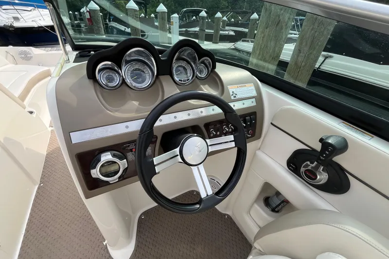 Slide: The Image of 2013 Sea Ray 280 Sundeck helm with steering wheel and control panel. - 20