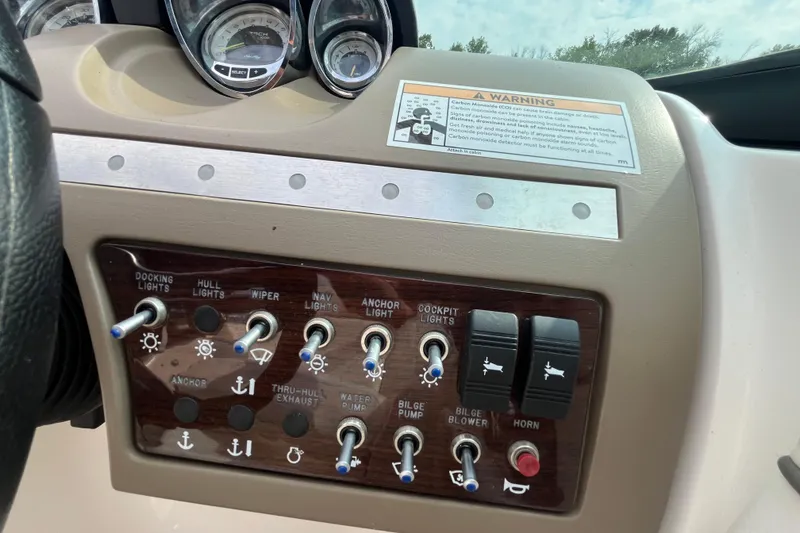 Slide: The Image of Control panel of a 2013 Sea Ray 280 Sundeck boat with various switches and gauges. - 22