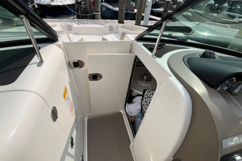 Slide: The Image of 2013 Sea Ray 280 Sundeck interior with open storage compartment and dashboard view. - 25