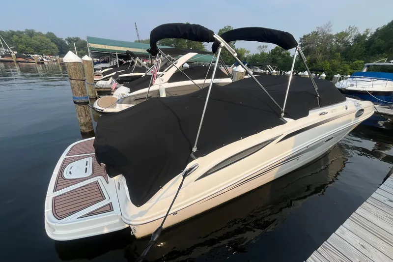 Slide: The Image of 2013 Sea Ray 280 Sundeck boat docked with black cover and bimini top. - 3