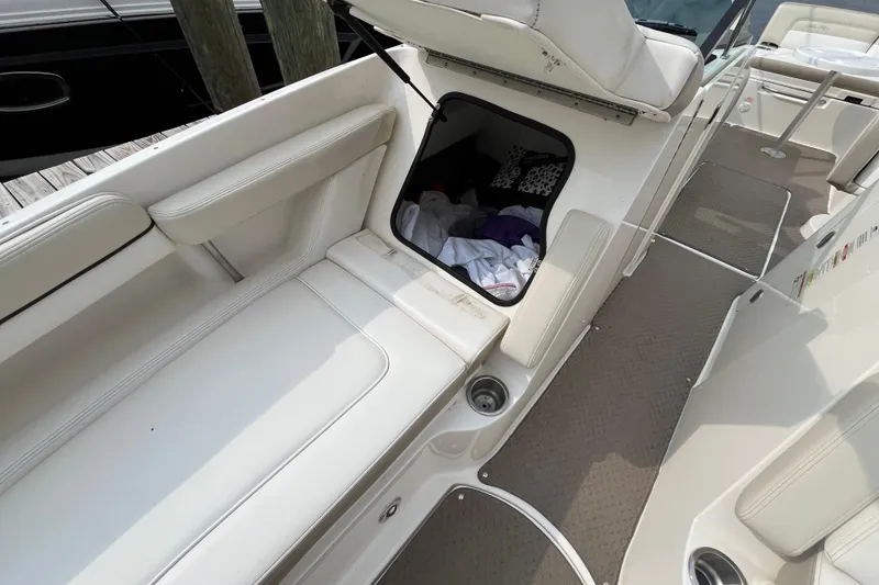Slide: The Image of 2013 Sea Ray 280 Sundeck interior with open storage compartment and seating. - 37
