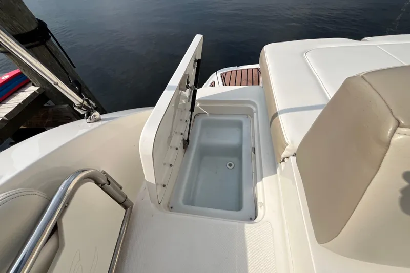 Slide: The Image of 2013 Sea Ray 280 Sundeck boat with open storage compartment by the water. - 44