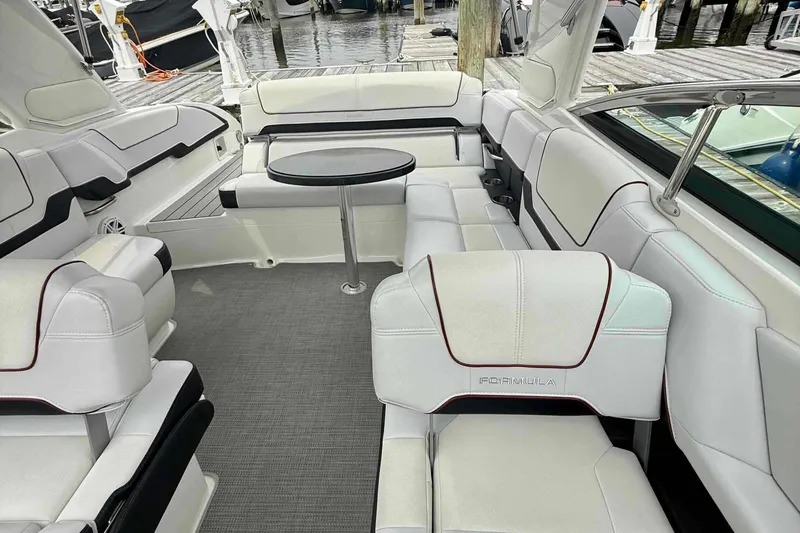 Slide: The Image of 2020 Formula 290 Bowrider interior with white seating and round table, docked at marina. - 16