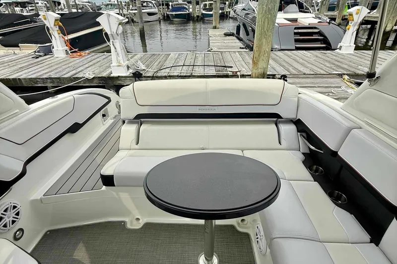 Slide: The Image of 2020 Formula 290 Bowrider interior with white seating and round table at marina. - 17