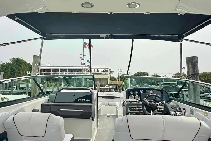 Slide: The Image of 2020 Formula 290 Bowrider interior with steering wheel and seating, docked at marina. - 18