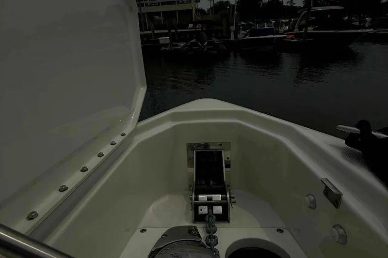 Slide: The Image of 2020 Formula 290 Bowrider anchor compartment at marina, showcasing open hatch and chain. - 24