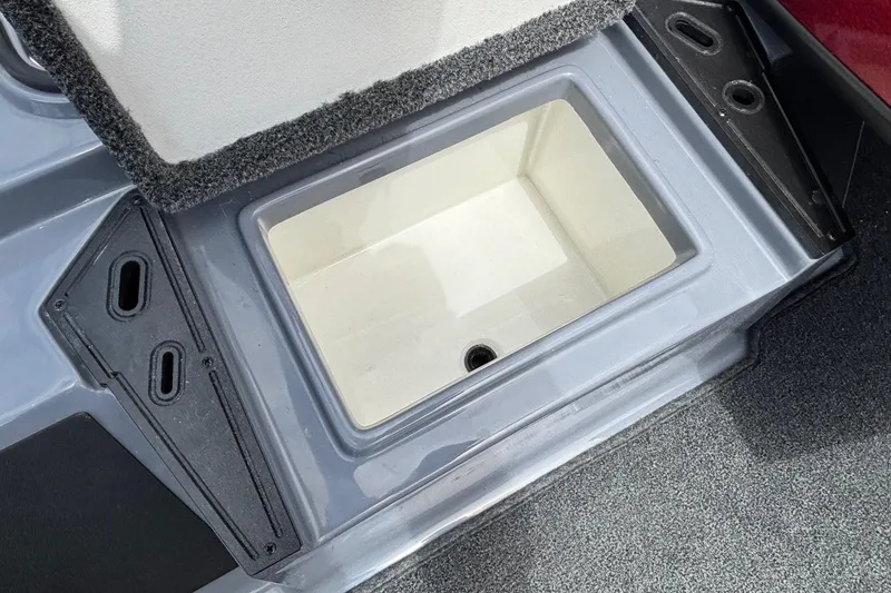 Slide: The Image of 2026 Ranger Z185 boat storage compartment with carpeted edges and drainage hole. - 7