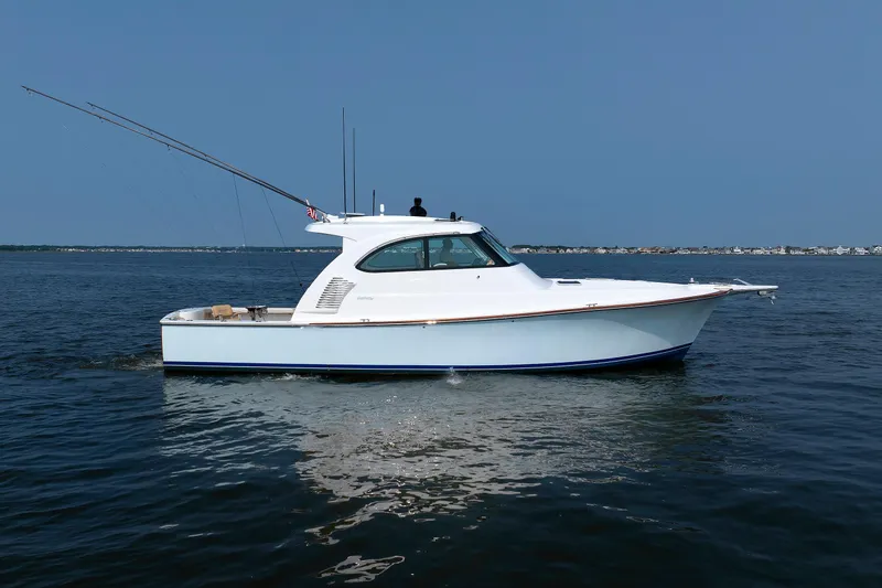 Slide: The Image of 2023 Henriques 42 Express Hardtop boat on calm water, side view. - 11