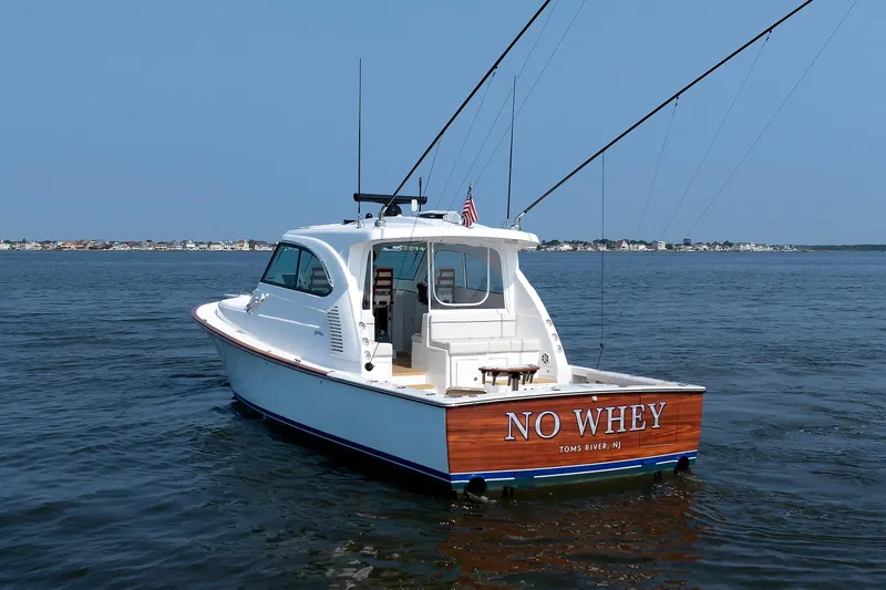 Slide: The Image of 2023 Henriques 42 Express Hardtop boat on water, rear view, "No Whey" name visible. - 12