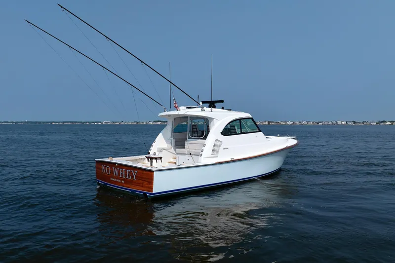 Slide: The Image of 2023 Henriques 42 Express Hardtop boat on calm water, clear sky background. - 14