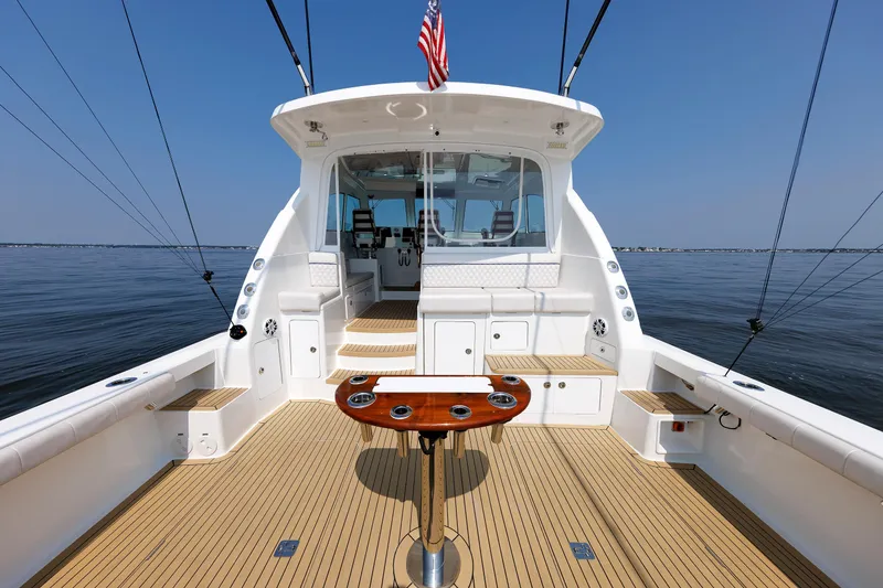 Slide: The Image of 2023 Henriques 42 Express Hardtop boat with spacious deck and fishing setup on calm water. - 17