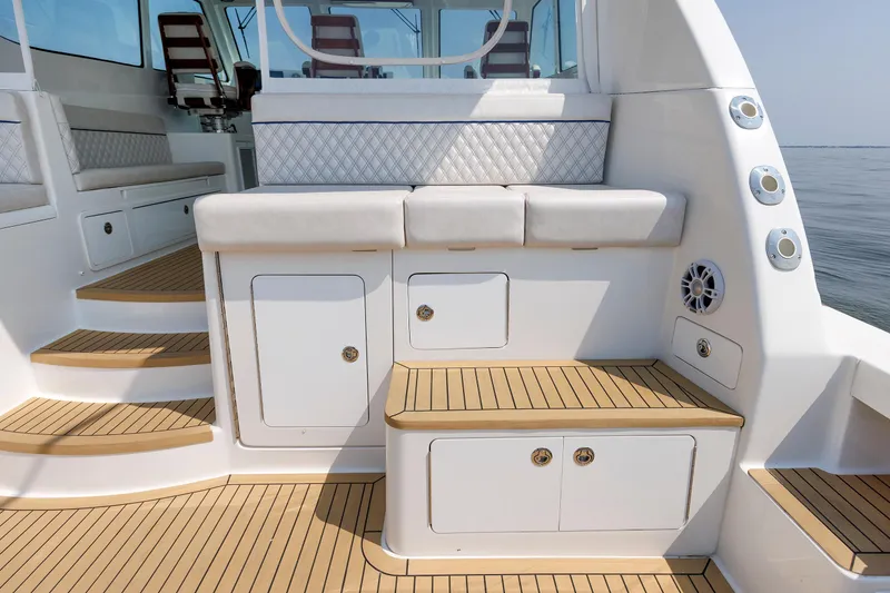 Slide: The Image of 2023 Henriques 42 Express Hardtop boat interior with cushioned seating and teak flooring. - 26