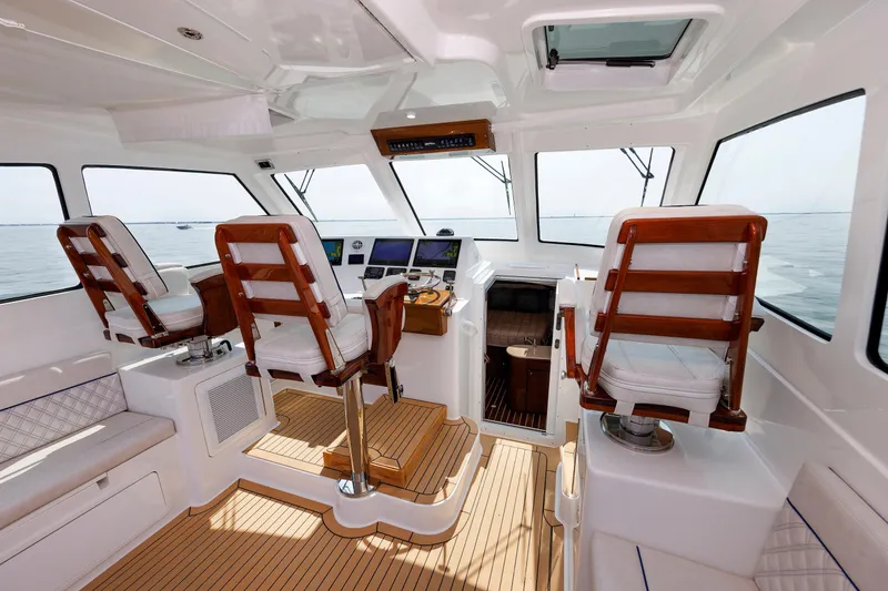 Slide: The Image of Interior of 2023 Henriques 42 Express Hardtop boat with wooden seating and navigation controls. - 31